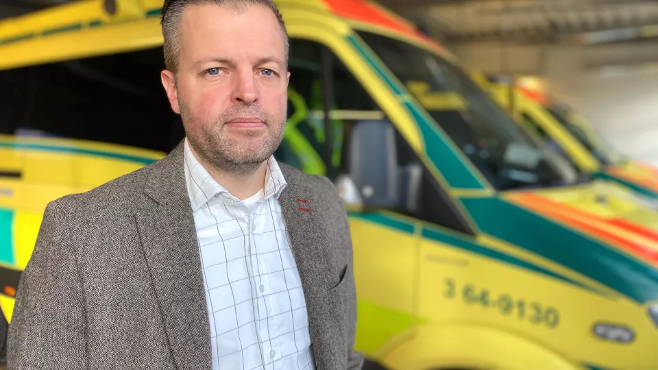 Andreas Rantala framför en ambulans. Foto.