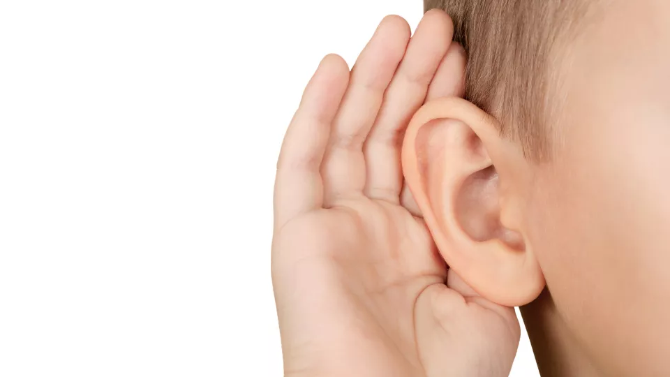 Ett anonymt barn håller handen bakom örat i en lyssnande gest