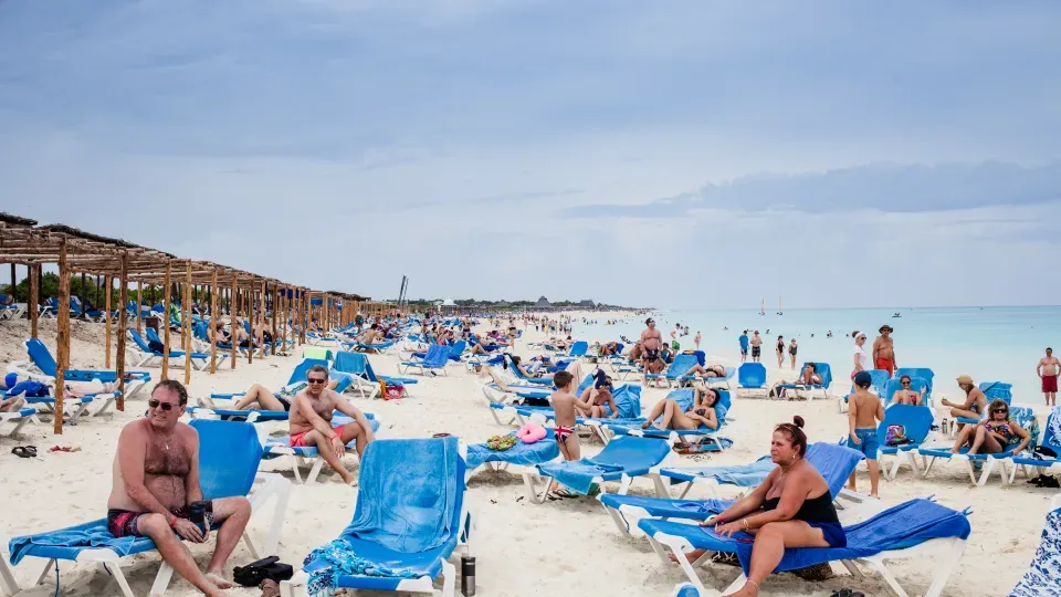 Strand full med människor som solbadar. Foto: Mostphotos