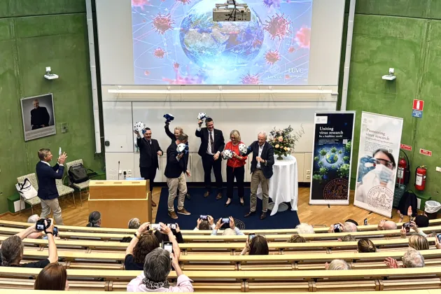 Fotografi av invigning då en virusmodell bröts iut av de som talade under invigningsceremonin. Foto: Agata Garpenlind