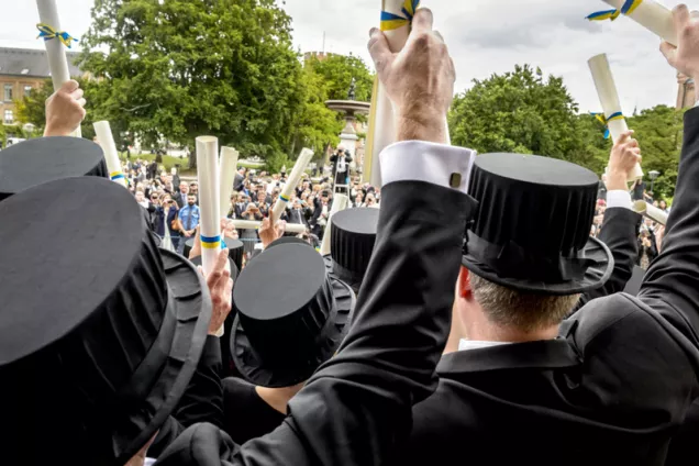 Doktorspromotion med högtidsklädda deltagare. Foto.