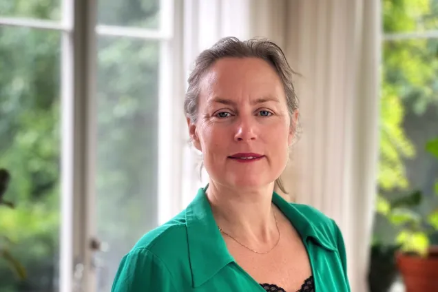 Porträtt av Emma Claesdotter-Knutsson i grön skjorta framför ett fönster. Foto Agata Garpenlind