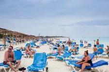 Strand full med människor som solbadar. Foto: Mostphotos