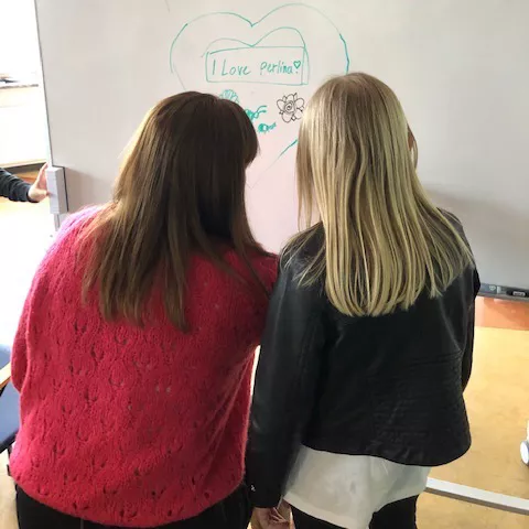 Illustration av Pernilla Stenström och ett av barnen på familjeträffen. Personerna på bilden har ryggen mot kameran.