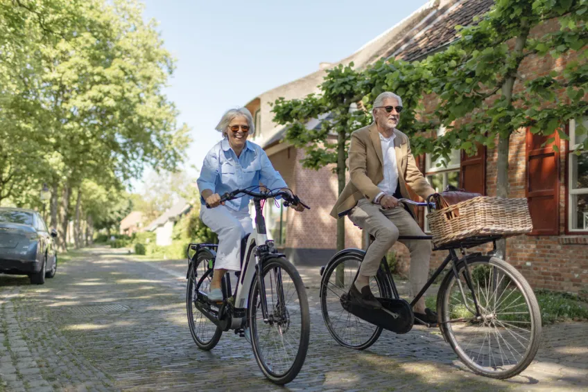 en äldre man och kvinna cykla i en småstad foto iStock