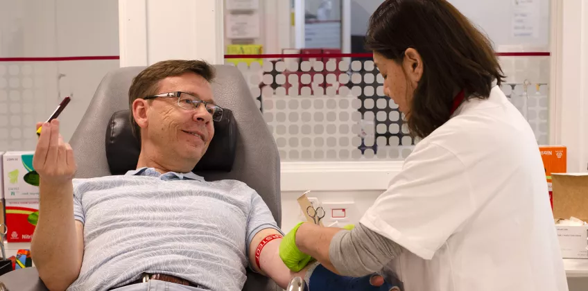 Sköterska startar blodgivning på forskaren Martin Olsson. Foto. 