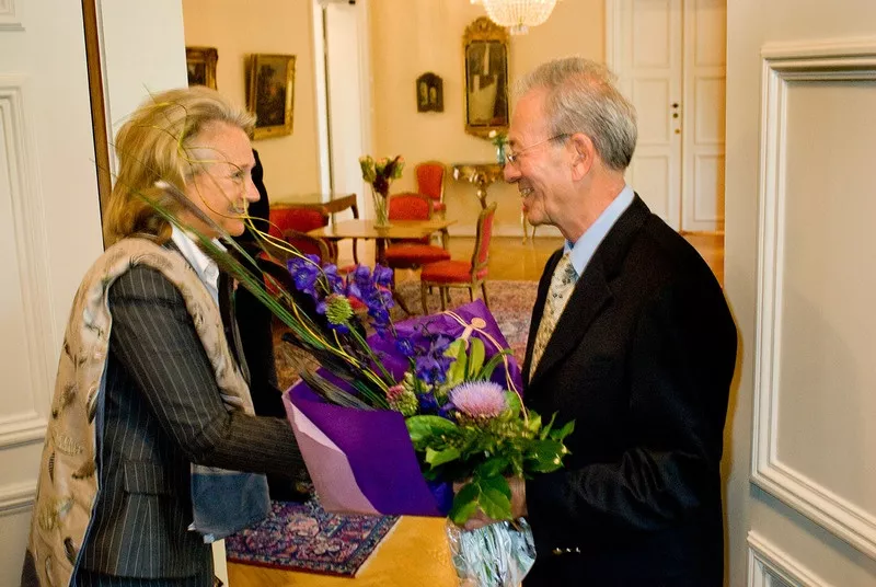 Professor Felix Mitelman med blommor tackar doktor. Elisabeth Edholm Fernström för priset. Foto.