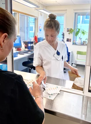Sjuksköterskan Josefin Berg byter använda sprutor till nya sterila. Foto.