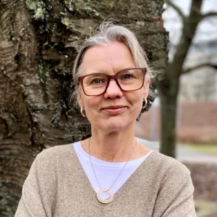 Porträtt av Pernilla Ny. Beige tröja, glasögon.
