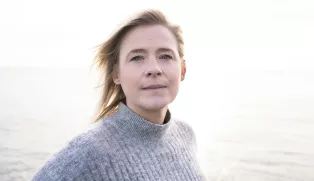 Kvinnoansikte som tittar in i kameran. Foto.